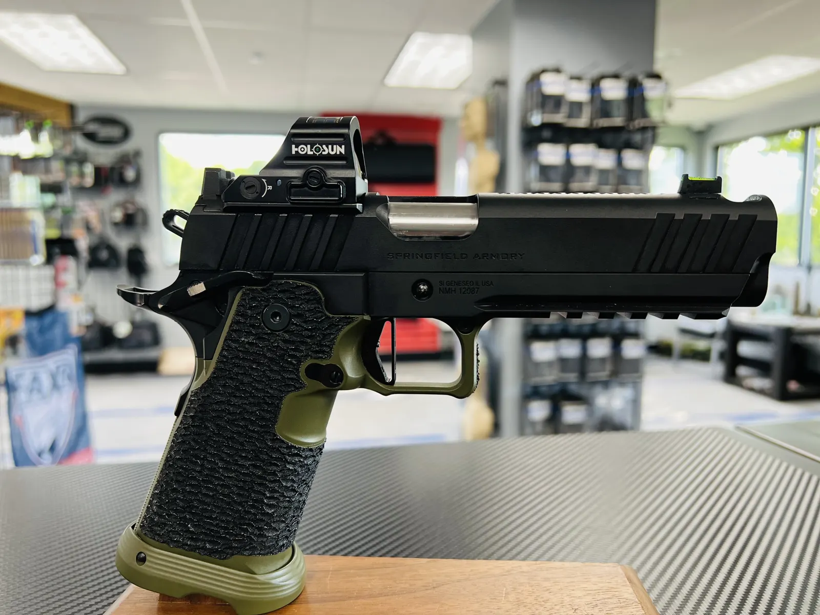 2011 pistol with green grip and optic
